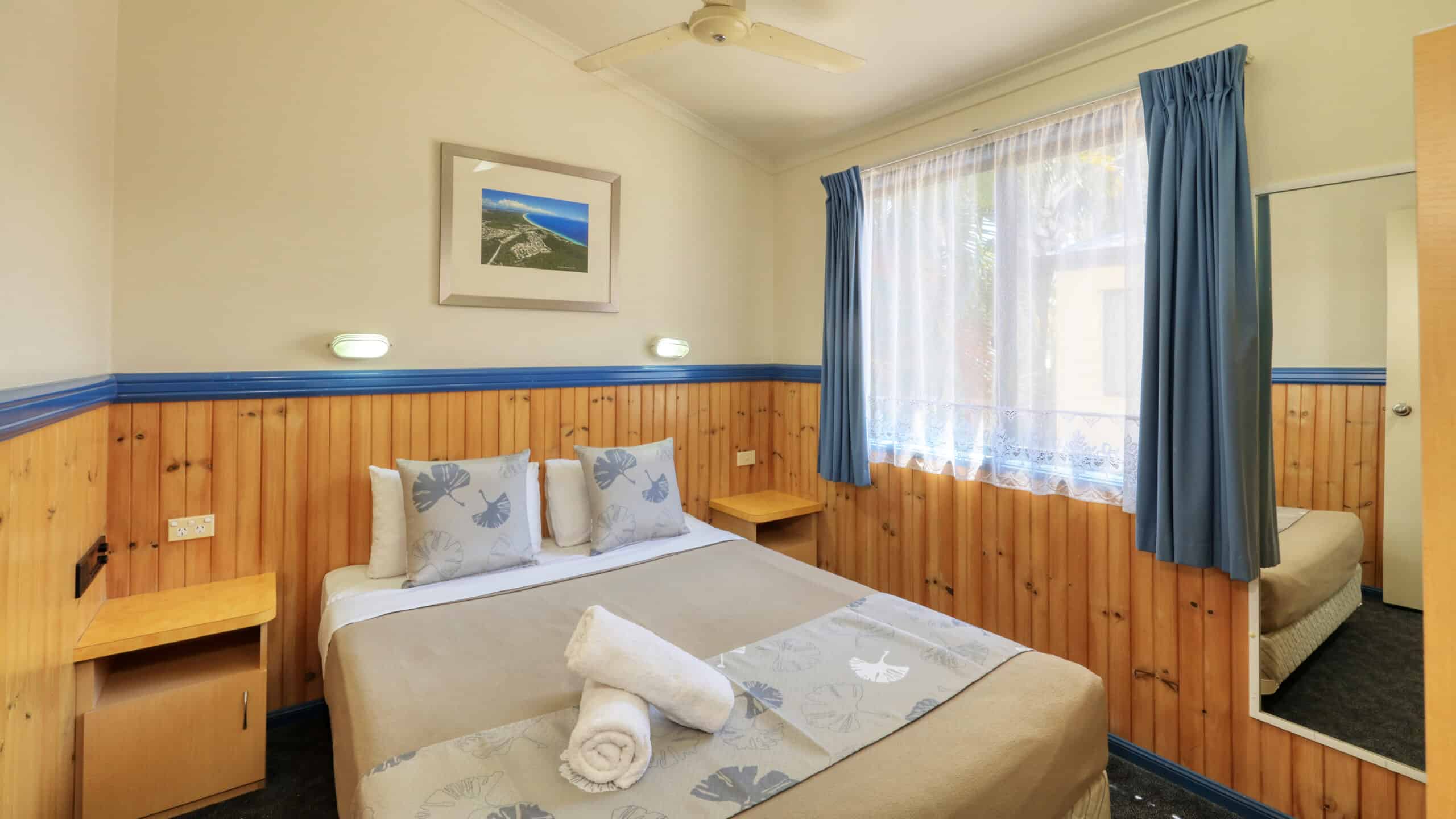 A queen size bed in a Chalet at Rainbow Beach Holiday Village