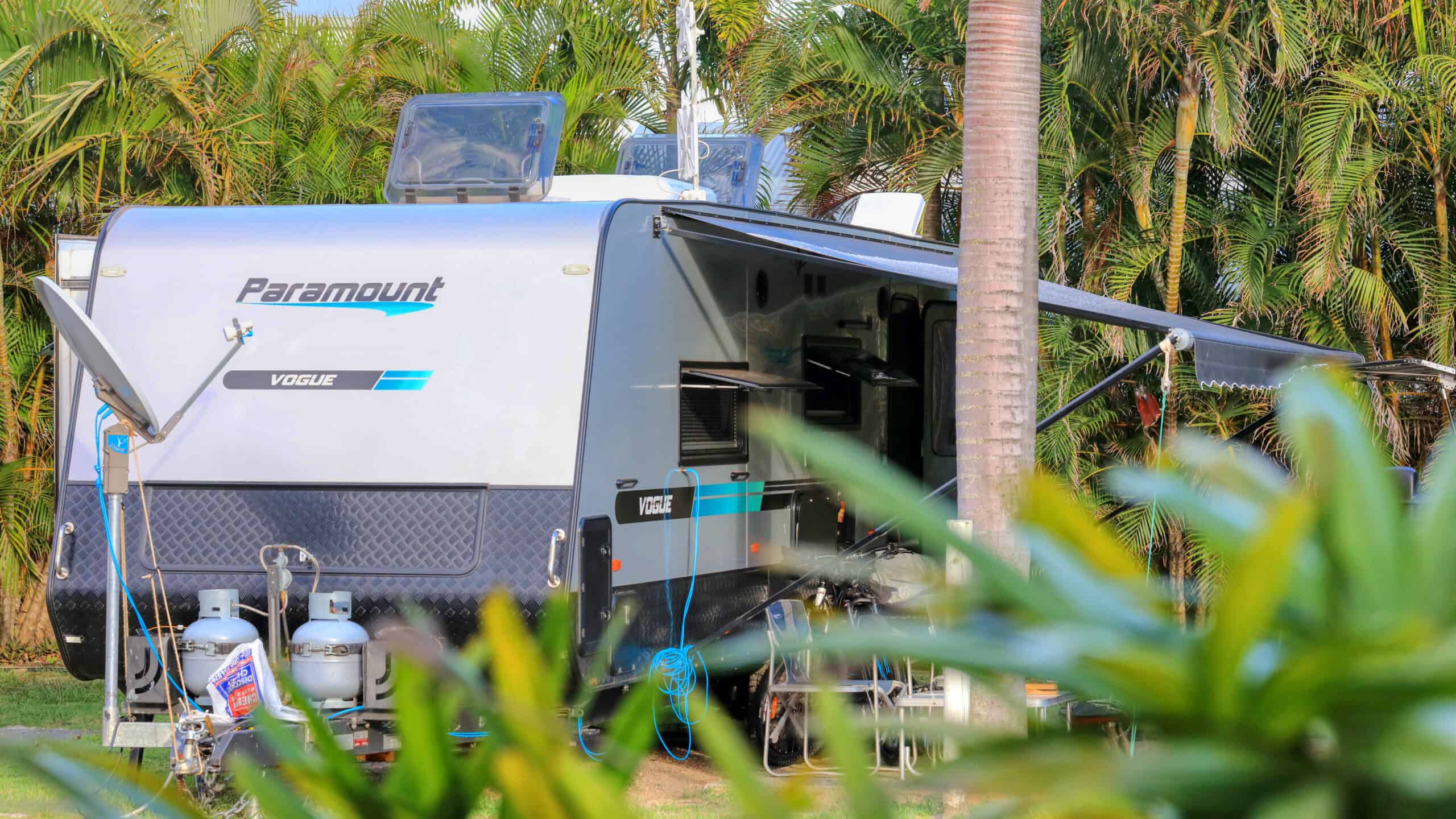 A caravan surrounded by trees at Rainbow Beach Holiday Village
