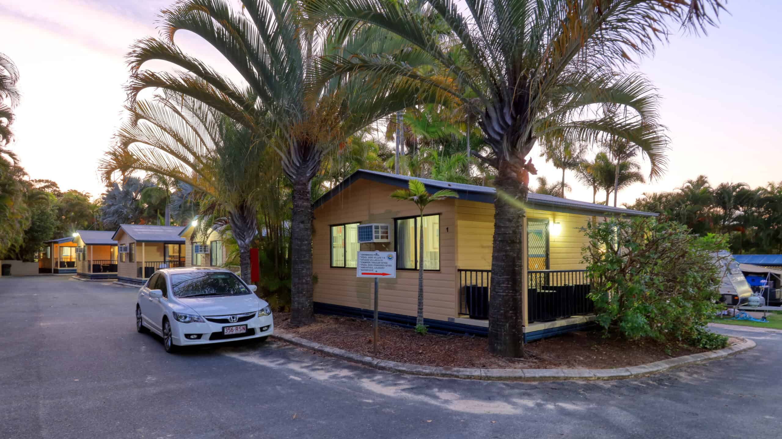 A car parked outside Chalet Cabins at Rainbow Beach Holiday Village