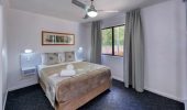 A queen size bed in a Villa at Rainbow Beach Holiday Village