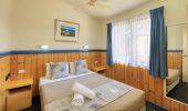 A queen size bed in a Chalet at Rainbow Beach Holiday Village