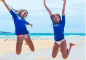 two girls jumping on the beach