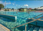 people swimming in a public pool