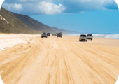 4WD vehicles driving along Rainbow Beach