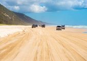 4WD vehicles driving along Rainbow Beach