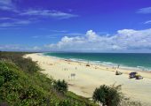 The surf at Rainbow Beach with clouds in the sky